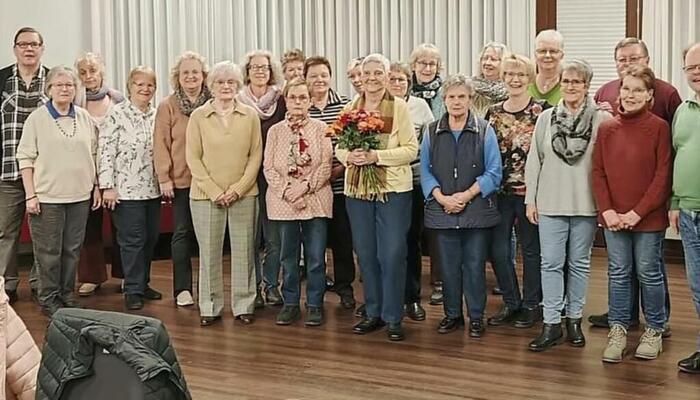 Doris Füller hält gerührt den Blumenstrauß in der Hand, umgeben von ihren Mitsängerinnen. © Privat